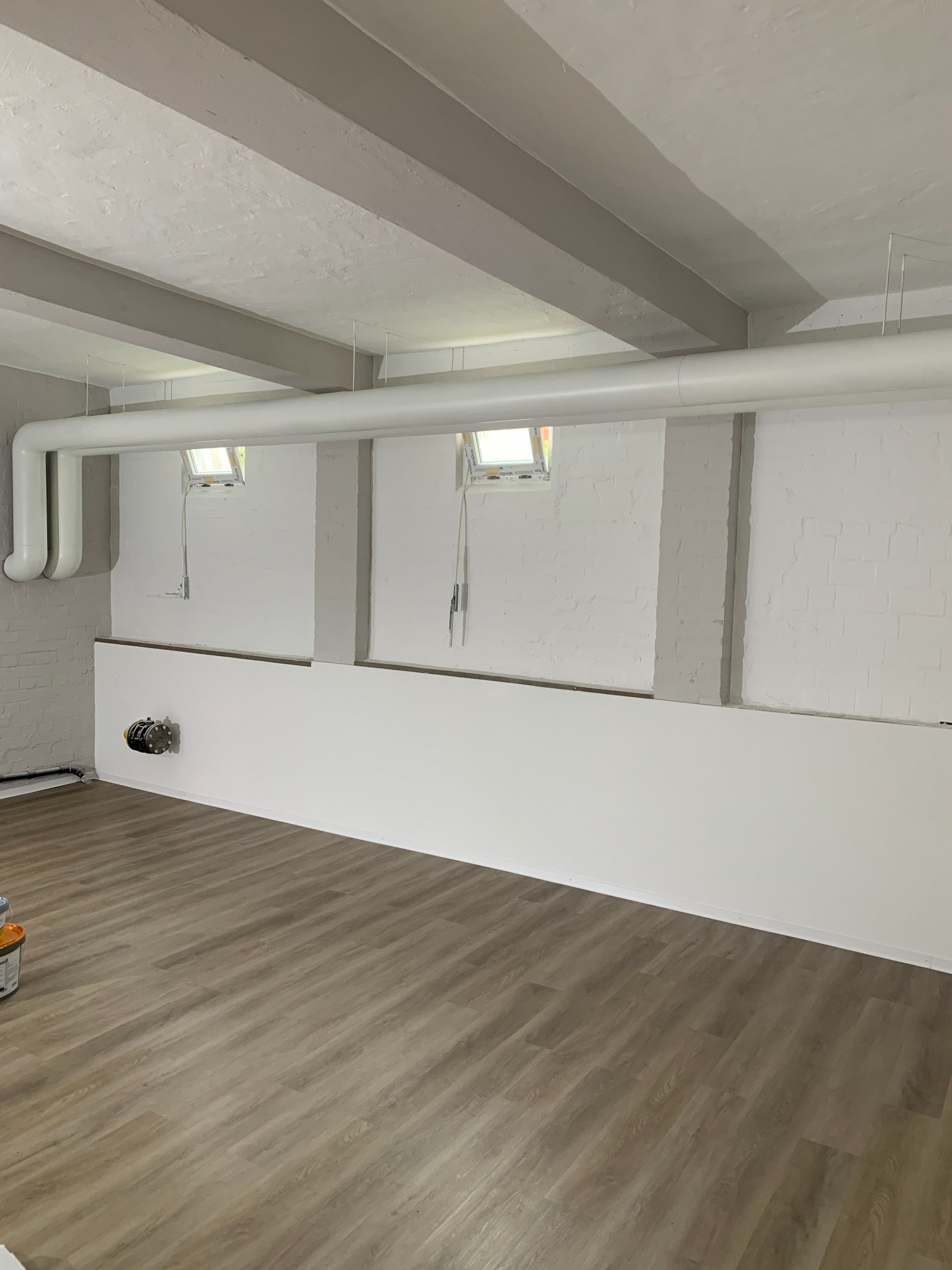 Beschichtete Wandflächen und neu verlegter Boden im Kellerraum