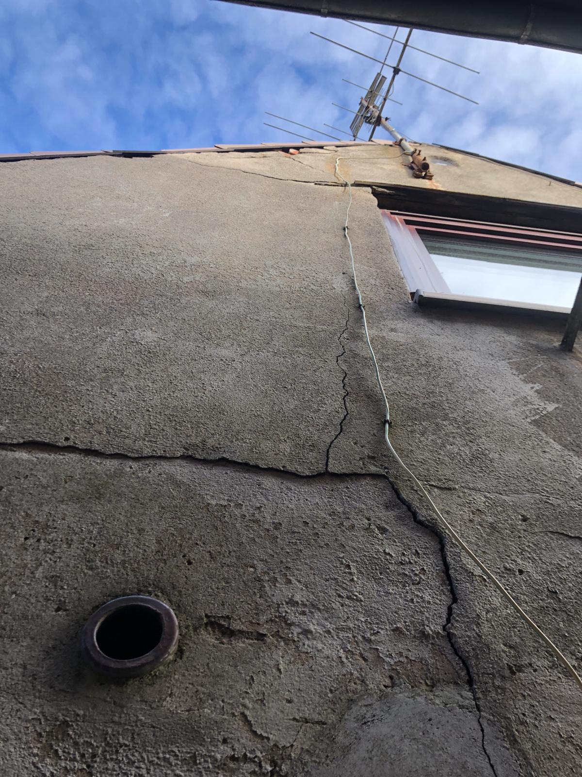 Risse und beschädigte Anschlüsse an einer Putzfassade
