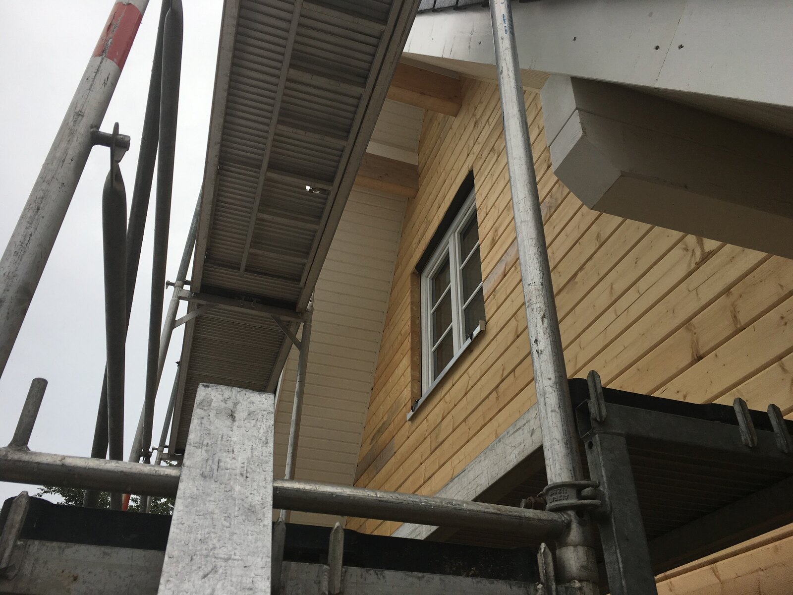 Unbehandelte Holzfassade am eingerüsteten Gebäude